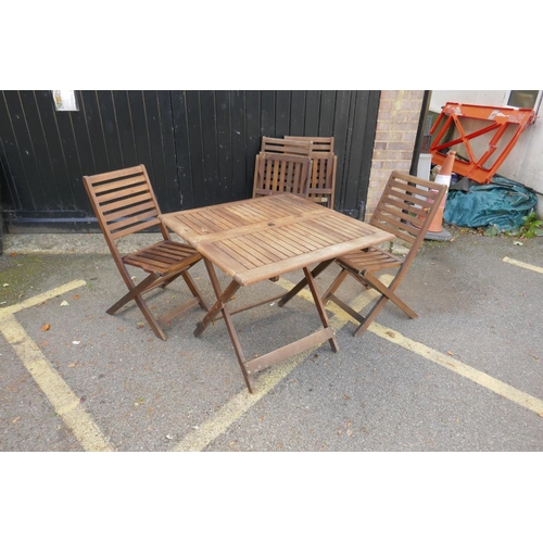 1153 - Four stacking teak garden chairs and a table