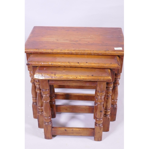 1157 - A nest of three Bevan Funnell oak occasional tables, raised on turned supports, 55 x 36 x 49cm