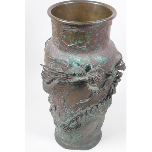 34 - A Japanese Meiji period bronze vase decorated with an entwined dragon, the base with embossed floral... 