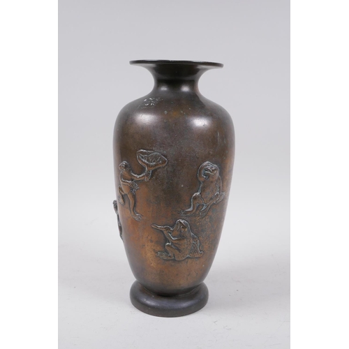 51 - A Japanese Meiji bronze vase decorated with playful frogs, the back engraved with calligraphy, drill... 