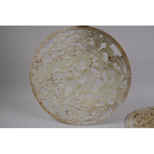 56 - A late C19th/early C20th Chinese carved and pierced celadon hardstone pi-disc with archaic dragon de... 