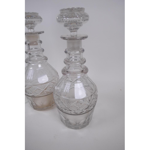 18 - A pair of Georgian three ring neck decanters with star cut decoration, 27cm high, and a near pair of... 