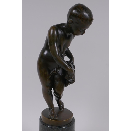 3 - A bronze figure of Cupid delivering love letters,  raised on a turned marble socle, 28cm high