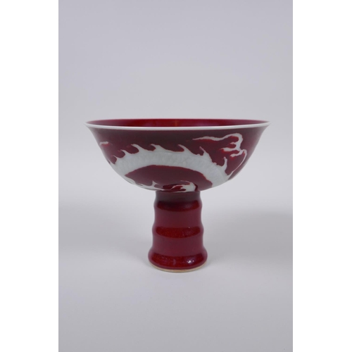 38 - A Chinese deep red glaze porcelain stem bowl with dragon decoration and ribbed stem, star crack to i... 