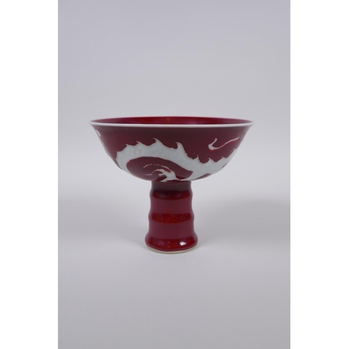 38 - A Chinese deep red glaze porcelain stem bowl with dragon decoration and ribbed stem, star crack to i... 