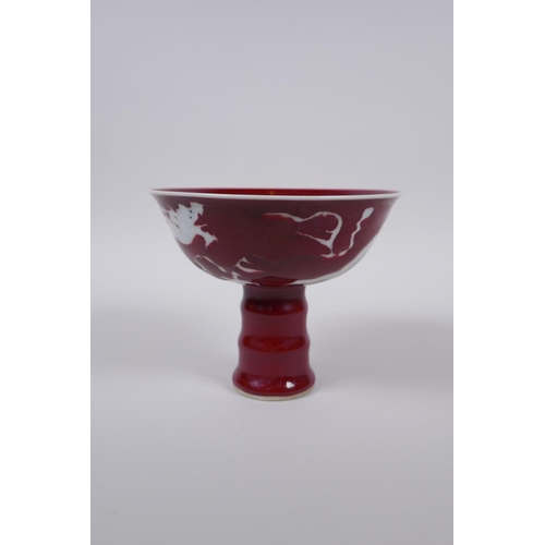 38 - A Chinese deep red glaze porcelain stem bowl with dragon decoration and ribbed stem, star crack to i... 