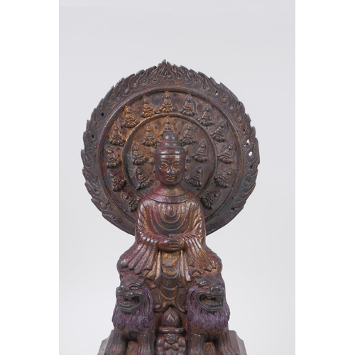 60 - A Sino Tibetan bronze Buddha seated upon fo-dogs, with remnants of gilt patina, 29cm high