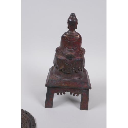 60 - A Sino Tibetan bronze Buddha seated upon fo-dogs, with remnants of gilt patina, 29cm high