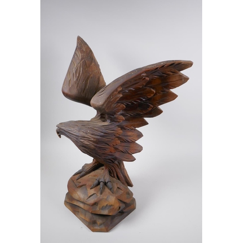 77 - A Black Forest carved wood figure of an eagle with outstretched wings, 52cm high