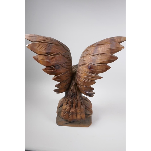 77 - A Black Forest carved wood figure of an eagle with outstretched wings, 52cm high