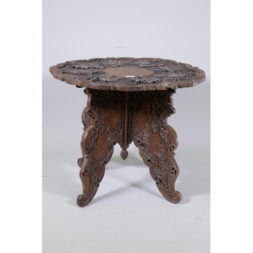 1144 - An eastern carved wood occasional table with shaped and pierced top and fold out base, AF, loss to t... 