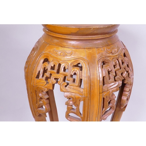 1139 - A Chinese jardiniere stand with carved and pierced details, raised on shaped supports with scroll fe... 