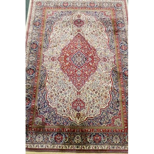 An ivory ground Kashmir carpet with central floral medallion design
