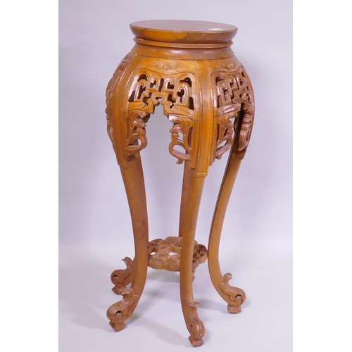 1139 - A Chinese jardiniere stand with carved and pierced details, raised on shaped supports with scroll fe... 