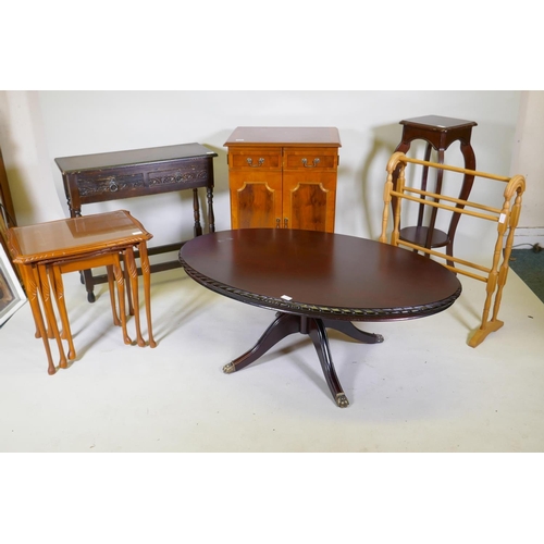 1141 - A yew wood media cabinet on bracket feet, an oak two drawer side table, an oval topped mahogany tabl... 