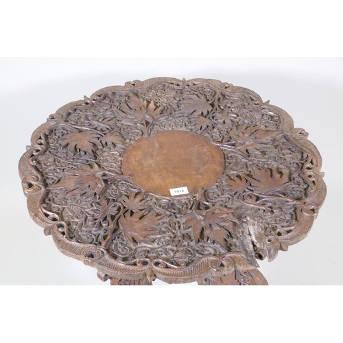 1144 - An eastern carved wood occasional table with shaped and pierced top and fold out base, AF, loss to t... 