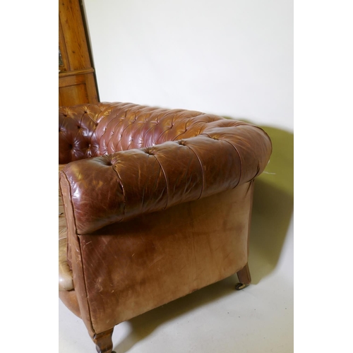 1150 - A leather chesterfield settee, raised on shaped beechwood supports, horse hair stuffed, springs need... 