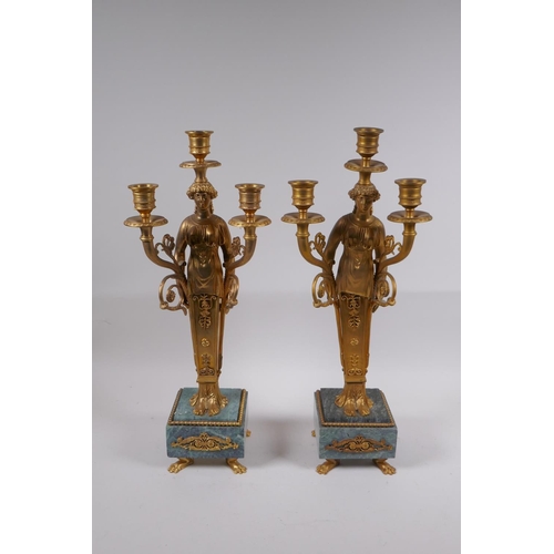 47 - A pair of Ormolu three branch candelabra in the form of Greco Roman women, raised on vert de mer bas... 