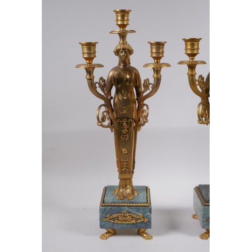 47 - A pair of Ormolu three branch candelabra in the form of Greco Roman women, raised on vert de mer bas... 