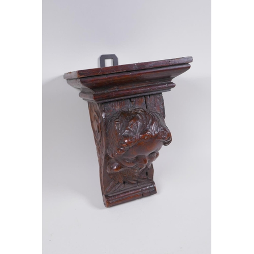 5 - A C17th adapted carved oak bracket/term, with cherub mask decoration, 23cm