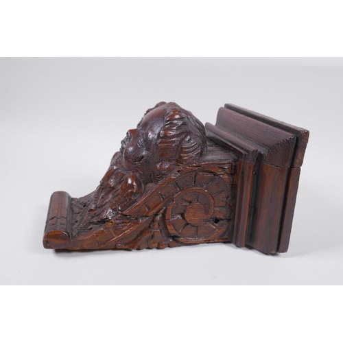 5 - A C17th adapted carved oak bracket/term, with cherub mask decoration, 23cm