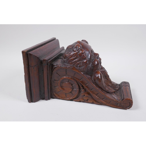 5 - A C17th adapted carved oak bracket/term, with cherub mask decoration, 23cm