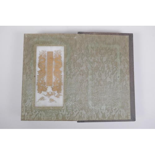 51 - A Chinese wood and fabric bound book containing white jade tablets with chased and gilt character in... 