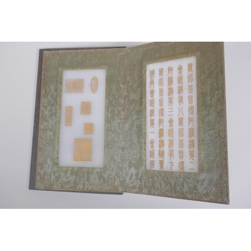 51 - A Chinese wood and fabric bound book containing white jade tablets with chased and gilt character in... 