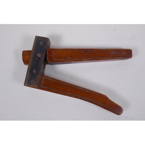 57 - An antique walnut nut cracker with copper plates, inscribed, 19cm long