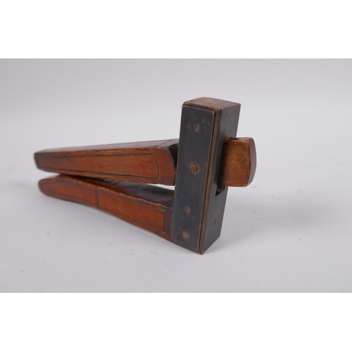 57 - An antique walnut nut cracker with copper plates, inscribed, 19cm long