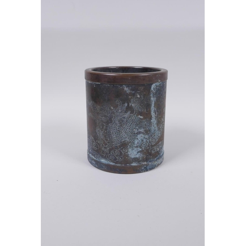 68 - A Chinese bronze brush pot with engraved kylin decoration, impressed mark to base, 12c, jogj