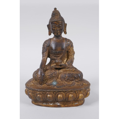 73 - A Tibetan bronze of Buddha seated on a lotus throne, with the remnants of gilt patina, 15cm high