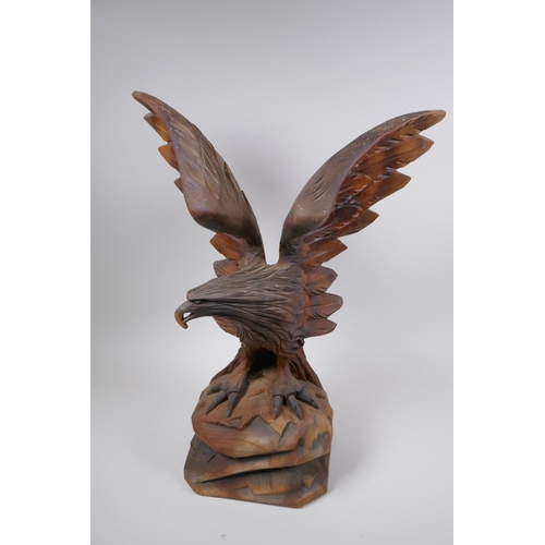 77 - A Black Forest carved wood figure of an eagle with outstretched wings, 52cm high