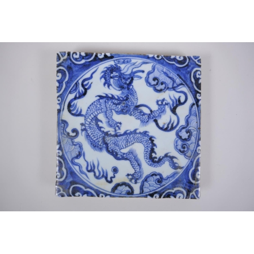 90 - A Chinese blue and white porcelain temple tile with dragon decoration, 20 x 20cm