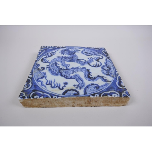 90 - A Chinese blue and white porcelain temple tile with dragon decoration, 20 x 20cm