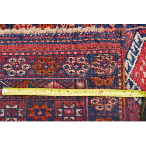 1152 - A Kurdish red ground full pile village rug/runner with unique geometric design, 290cm x 98cm