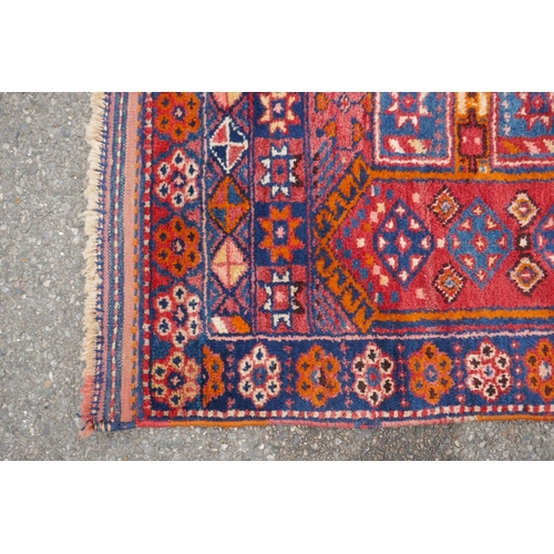 1152 - A Kurdish red ground full pile village rug/runner with unique geometric design, 290cm x 98cm