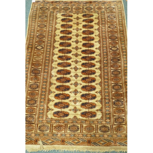 1110 - A Bokhara wool rug with geometric designs on a gold field, 180 x 120cm