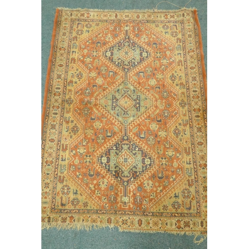 1125 - A Middle Eastern wool carpet with medallion design on a faded terracotta field, 160 x 110cm