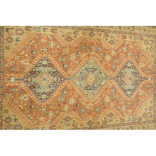 1125 - A Middle Eastern wool carpet with medallion design on a faded terracotta field, 160 x 110cm