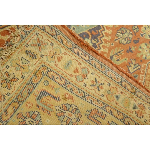 1125 - A Middle Eastern wool carpet with medallion design on a faded terracotta field, 160 x 110cm