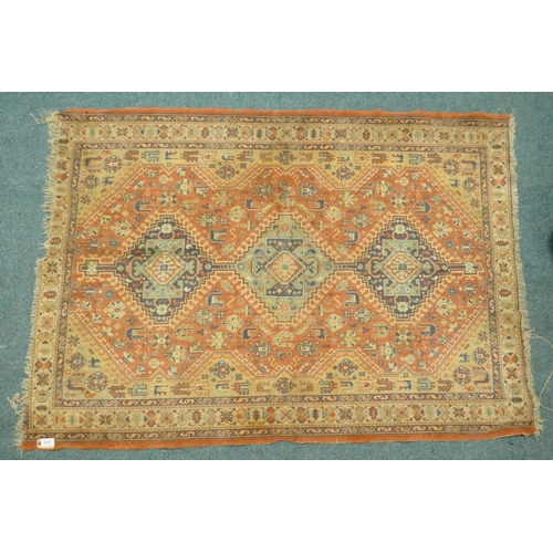 1125 - A Middle Eastern wool carpet with medallion design on a faded terracotta field, 160 x 110cm