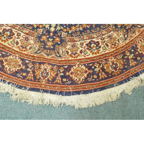 1126 - A wool carpet with Persian style designs on a red field with blue borders, 180cm diameter