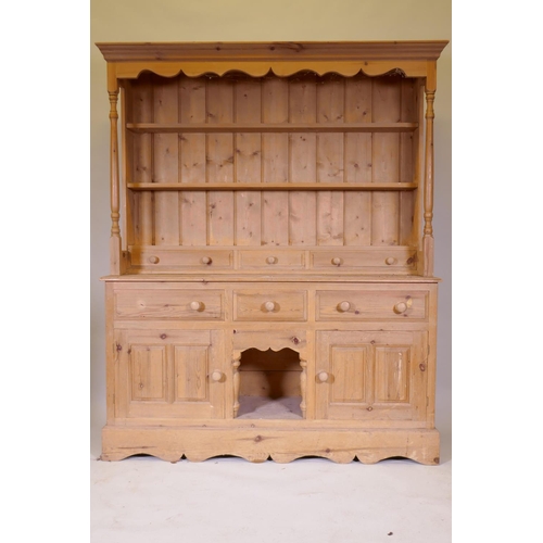 1111 - A pine dresser with an open delft rack, the base with two cupboards flanking a dog kennel, 158 x 43c... 