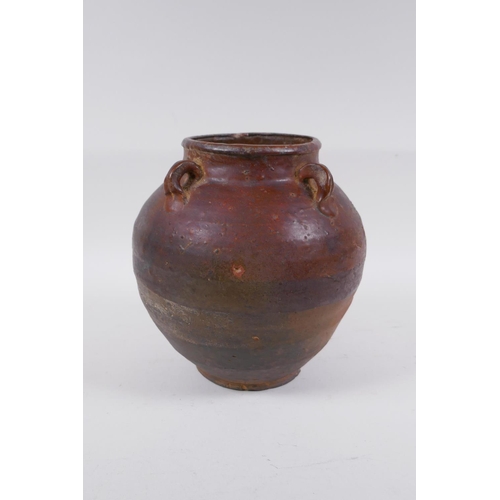 232 - A antique glazed terracotta jar with four lug handles, 20cm high