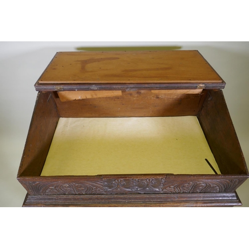 1023 - A carved oak bible box on stand, with triple panel fall front, the stand raised on baluster turned s... 