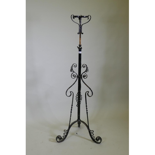 1031 - A Victorian wrought iron telescopic floor lamp stand, 138cm high, 200cm extended