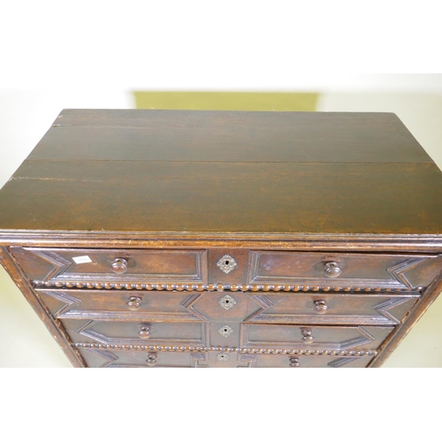 1039 - A Jacobean oak chest of five drawers, with moulded and bobbin turned decoration, raised on bun suppo... 