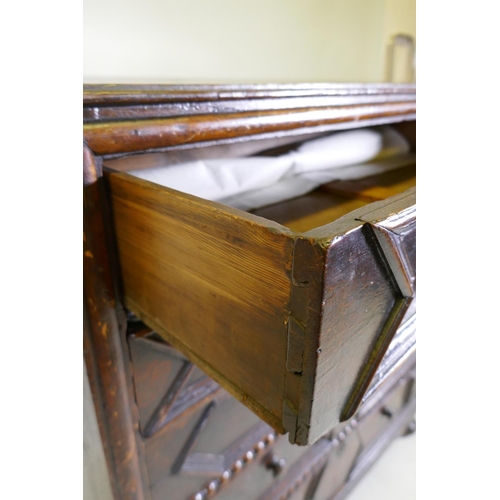 1039 - A Jacobean oak chest of five drawers, with moulded and bobbin turned decoration, raised on bun suppo... 