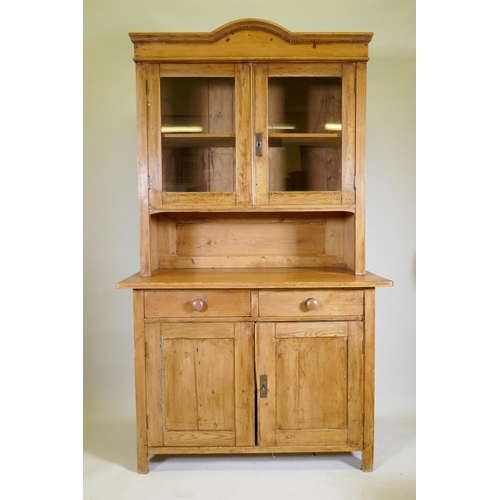 1040 - A C19th continental pine dresser, the upper section with two glazed doors, the base with two drawers... 